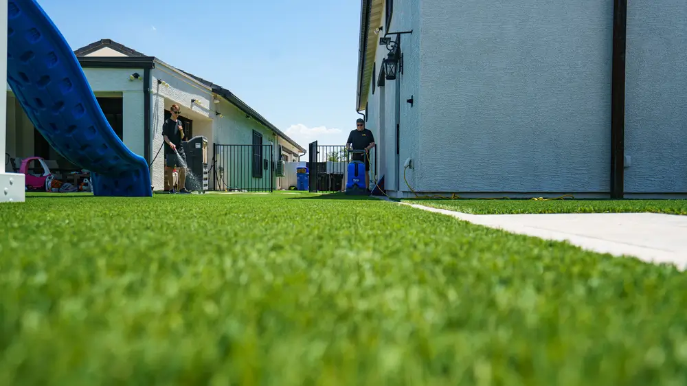 Technician deep-cleaning turf in a Mesa backyard